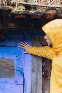 Side view portrait of boy standing on wood