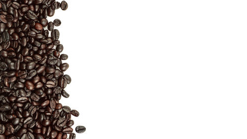 High angle view of coffee beans against white background