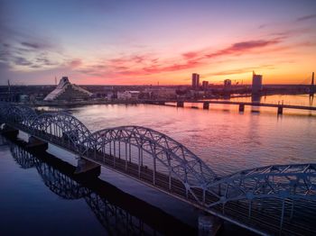 Bridge over river against sky during sunset