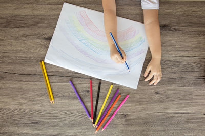 High angle view of woman reading book on table