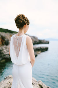 Rear view of woman looking at sea against sky