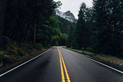 Empty country road in forest against mountain