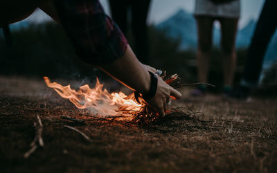 Woman stsrting a bonfire on wooden log