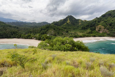 Scenic view of river by mountains against sky