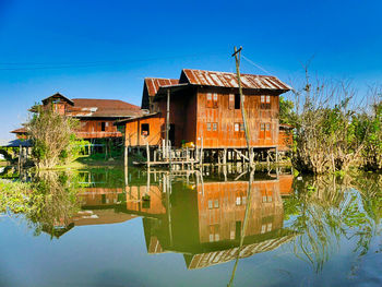 Reflection of building on lake against blue sky