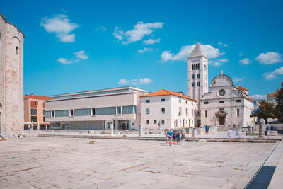 Buildings in city against blue sky