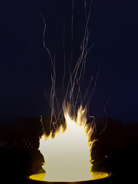 Firework display against sky at night