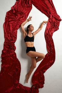 Portrait of woman standing against curtain