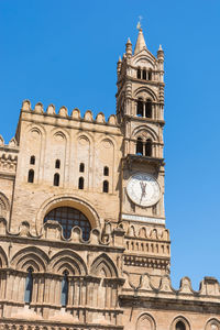 Low angle view of clock tower against blue sky