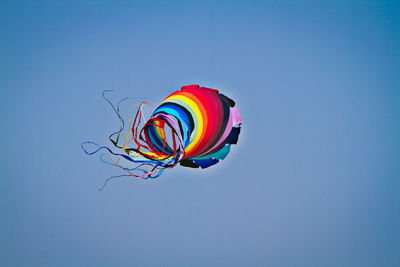 Low angle view of colorful kite flying against clear sky