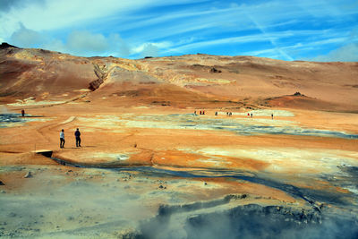 Scenic view of desert against cloudy sky