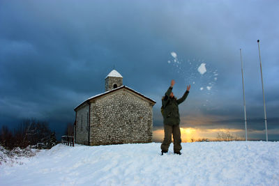 Rear view of man standing on snow covered land