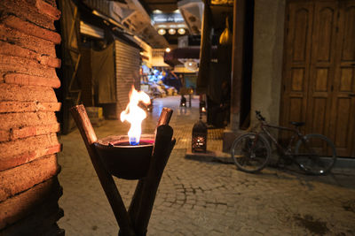 People on illuminated street amidst buildings at night