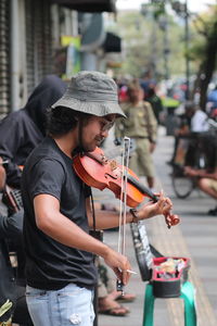 A man playing violin on street in city