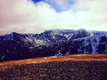 Scenic view of mountains against cloudy sky during winter