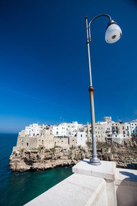 Low angle view of street light against townscape and sky