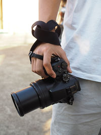 Midsection of man photographing camera