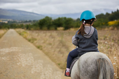 5 year old girl riding a horse with lovely expression