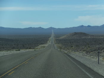 Empty road leading towards mountains