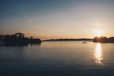 Scenic view of lake against sky at sunset