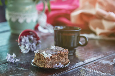 Aesthetic homemade chocolate cake. dessert and cup of coffee among flowers. atmospheric breakfast