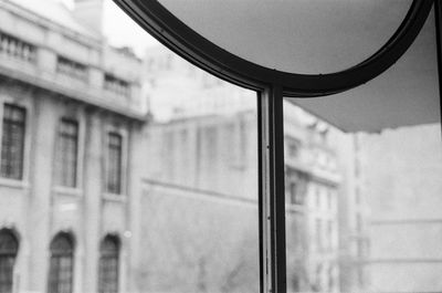 Low angle view of building seen through glass window