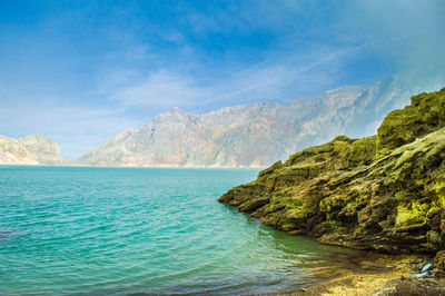 Scenic view of sea and mountains against sky