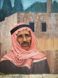 Portrait of man wearing hat against wall