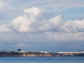 Scenic view of sea by buildings against sky