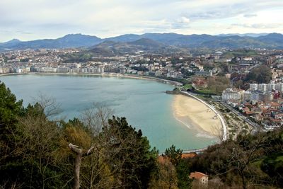 High angle view of city by sea against sky