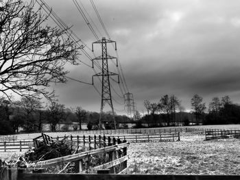 Electricity pylon on field against sky