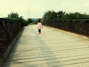 Rear view of woman walking on road