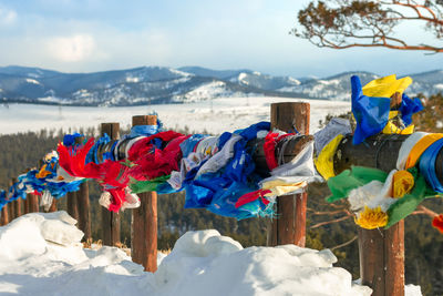 Prayer flags with tibetan mantras in wind at snowy temple complex, asian culture at local monastery