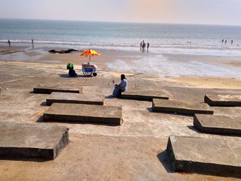 People enjoying of beach against sky