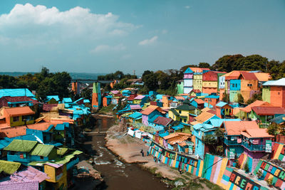 High angle view of river amidst colorful houses against sky