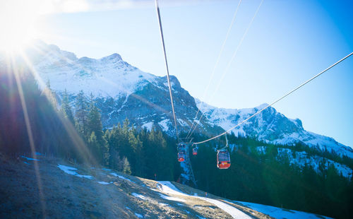 Overhead cable car over snowcapped mountains against sky