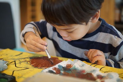 Portrait of boy holding ice cream on table