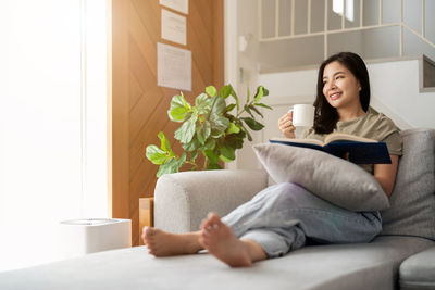 Portrait of woman sitting on sofa at home