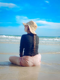 Rear view of woman standing at beach