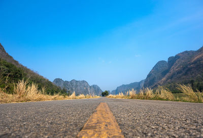 Surface level of road against blue sky