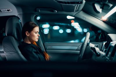 Side view of woman sitting in car