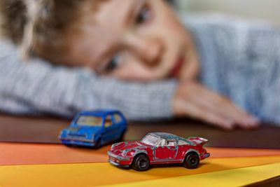 Close-up of boy playing with toy car at home