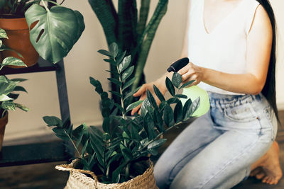 Midsection of man holding woman standing against plants