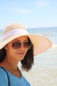 Portrait of young woman wearing sunglasses hat