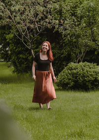 Happy ginger hair woman walking barefoot in the park or garden. freedom and healthy way of life