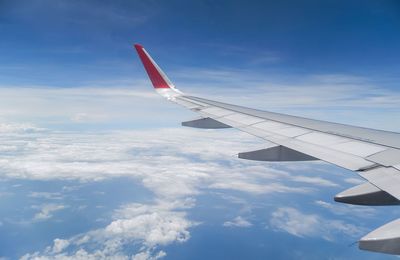 Airplane flying over clouds against blue sky