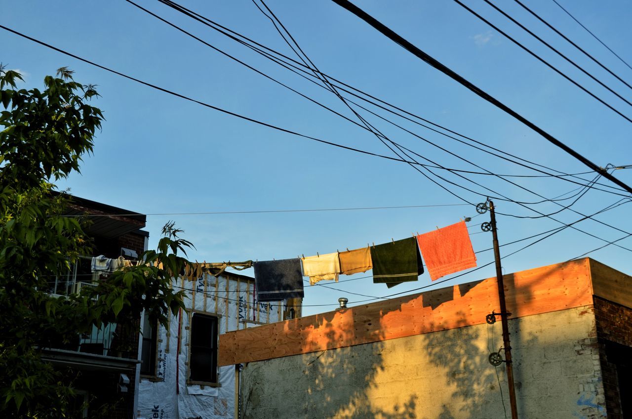 LOW ANGLE VIEW OF FLAG AGAINST BUILDINGS AGAINST CLEAR BLUE SKY