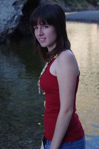 Side view portrait of woman standing at lakeshore