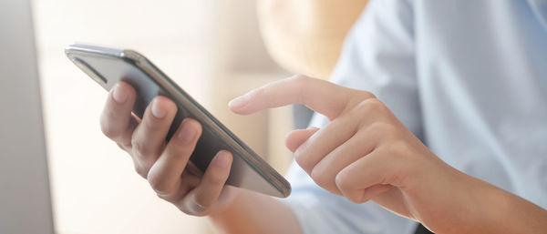 Midsection of man using mobile phone
