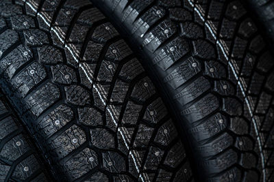 Close-up black new studded tires for winter driving in a car